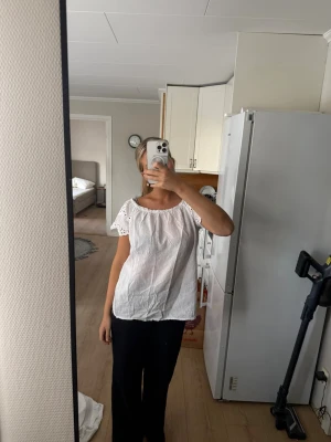 Vit blus med spetsdetaljer - Söt vit blus med korta ärmar och broderade spetsdetaljer på ärmarna. Blusen har en lös passform och rundad halsringning med resår💕