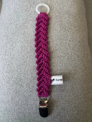 Virkad napphållare - Virkad, lila/rosa napphållare, virkad av mig i 100% bomullsgarn med metallclips och silikonring.  Mönsterskapare: animo.design 