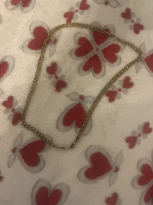 Guldfärgat kedjehalsband - Snyggt halsband i guldfärg med klassisk kedjedesign. Halsbandet har en enkel men stilren look och passar perfekt för dig som gillar accessoarer som sticker ut lite extra. Materialet ser ut att vara metall med en glansig finish.