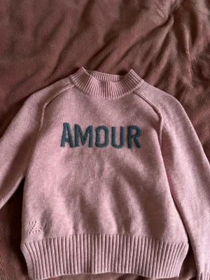 Zadig Voltaire tröja - Söt rosa stickad tröja med texten AMOUR broderad framtill i blått. Tröjan har ribbade muddar vid hals, ärmslut och nederkant samt lång ärm. Perfekt för dig som gillar en mysig och trendig look.