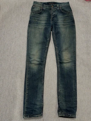 Nudie Jeans - Nudie Jeans Grim Tim i storleken 29/32. Extremt  unik och snygg modell som ej säljs längre. I mycket gott skick, bortsett från några lösa sömmar på ena bakfickan.