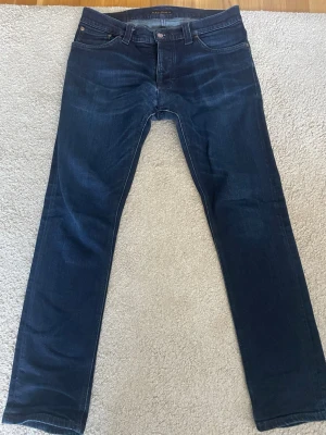 Nudie jeans  - Säljer dessa otroligt feta nudie jeansen i storlek 32 | modell - Grim Tim | nypris 2200 | mitt pris 699 kr | enligt mig den fetaste tvätten på jeans jag sett | 2 defekter vid väcket men igensytt hos nudie | se bild 4 och 5 | hör av er vid fler funderingar | 