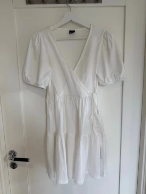 Vit klänning  - Vit söt klänning med knytdetalj på sidan från Gina Tricot storlek S som passar perfekt till sommaren☀️