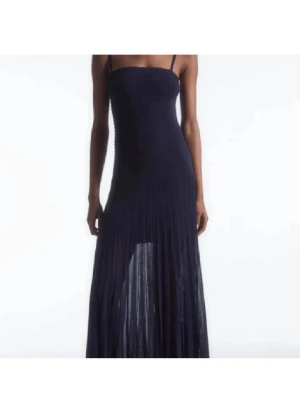 Marinblå långklänning COS PLISSERAD - Snygg plisserad eftertraktad marinblå långklänning från  COS. Har små små fläckar. Storlek M, men är bara lite för stor för mig som bär xs