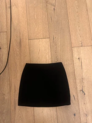 Svart kortkjol från hm  - En stilren svart kortkjol,  Kjolen har en enkel och klassisk design med rak passform, perfekt för att matcha med olika toppar och sneakers eller boots. Passar dig som gillar minimalistiskt och tidlöst mode.