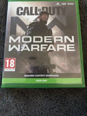 Call of Duty: Modern Warfare Xbox One - Säljer Call of Duty: Modern Warfare till Xbox One. Spelet kommer i original grön plastbox med omslag och skiva. Omslaget har en mörk, militärinspirerad design med soldatmotiv. Perfekt för dig som gillar action och FPS-spel.
