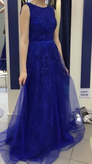 Blå balklänning - Djupblå balklänning från Juju & Christine, endast använd en kväll!  -extra Insydd till en xs i midjan (ca 74 cm)  -100% Polyester  - Ca 140 cm lång från nyckelben och ner (ca 105 cm kjol)  - Matchande blå sjal ingår  - Insydd bystvaddering