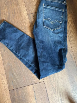 Mörkblå slim jeans med kontrastsömmar - Snygga mörkblå slim jeans med kontrastsömmar och klassisk femficksdesign. Jeansen har en diskret tvättad look och raka ben. Bakfickan har ett coolt broderat mönster. Perfekta till en avslappnad streetstyle storlek 28-32