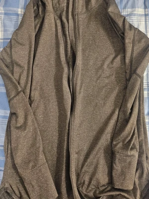 Mörkgrå hoodie med dragkedja - En stilren mörkgrå hoodie med dragkedja framtill och huva. Hoodien har långa ärmar och två fickor på sidorna. Perfekt för en avslappnad och bekväm look.