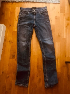 Mörkblå raka jeans från replay - Snygga mörkblå jeans från replay med klassisk femficksdesign och raka ben. Jeansen har en diskret tvättad look och är tillverkade i denim med lätt stretch för extra komfort. Perfekta för en avslappnad och stilren vardagsstil.
