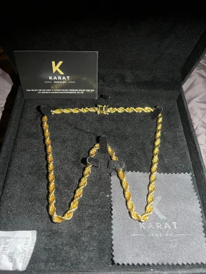 Guldlänk halsband från Karat Jewelry - Säljer ett snyggt halsband från Karat Jewelry med tvinnad guldlänk. Halsbandet har en glansig finish och känns riktigt lyxigt. Perfekt accessoar för dig som vill sticka ut med en klassisk men modern guldfärgad kedja.