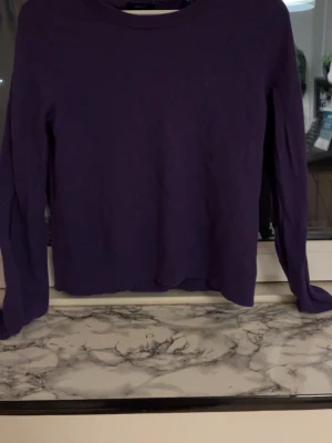 Lila stickad tröja från Gant - Säljer en lila stickad tröja från Gant i superfin lammull. Tröjan har rund halsringning, långa ärmar och ribbade muddar.  Den har krympt i tvätten så nu är storleken xs ungefär men perfekt för dig som vill ha en enkel men snygg stickad tröja i mjukt material. 