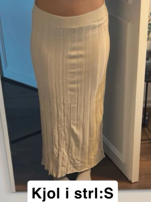 Beige långkjol - Snygg beige mjuk och skön långkjol. Kjolen har en rak passform och är perfekt för dig som gillar en stilren och elegant look. Tjock kant vid midjan som gör att den sitter bekvämt