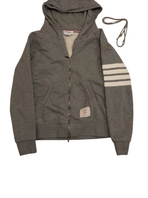 Thom Browne tröja - Säljer denna äkta thom Browne tröjan  i storlek 2 vilket motsvarar s-m, inga defekter förutom snöret som har gått sönder på ena sidan går att köpa nytt kom privat för fler frågor och funderingar