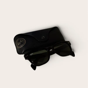 Ray-Ban RB0880S (Svart) – Som nyskick - Säljer ett par Ray-Ban i modellen RB0880S. Detta är en snygg, lite kraftigare båge med retro-känsla (påminner om Wayfarer men med modernare snitt).  Originalfodral i svart läder medföljer.  Skick: Extremt bra skick! Bedöms som nyskick. 