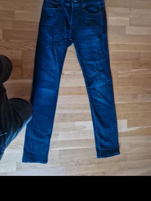 Mörkblå slim fit jeans Slim/Glenn - Snygga mörkblå jeans i slim fit-modell från Slim/Glenn. Klassisk femficksdesign, raka ben och diskreta slitningar. Perfekta för dig som gillar en smalare passform och tidlös stil. Tillverkade i mjukt denimtyg som sitter skönt hela dagen.