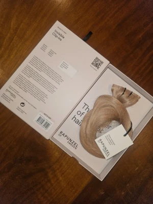 Löshår från rapunzel  - Säljer ett set blonda Invisible Clip-ins från Rapunzel of Sweden. Helt nytt! Längd 50 cm, se färgkod på kartongen!