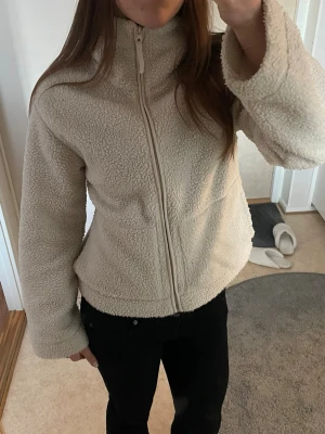 Beige/krämvit teddyjacka med hög krage - Mysig beige teddyjacka med hög krage och hel dragkedja framtill. Använd fåtal gånger🤍