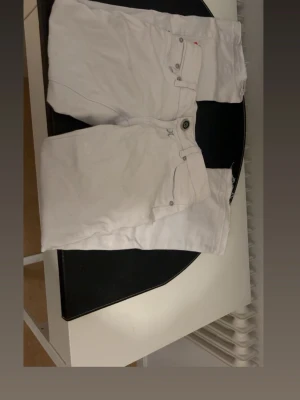 Vita miss Vivi  jeans med krona - Säljer ett par vita miss Vivi jeans med lågmidjade och bootcut. Midjemåttet är 38cm rakt över och innerbenslängden är 68cm. De är jättefina men knappen är lös och behöver sättas fast💗💗