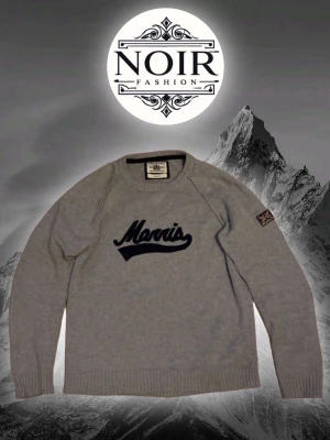 Grå stickad tröja från Morris - Snygg grå stickad tröja från Morris med mörkblå broderad logga på bröstet och Union Jack-märke på ärmen. Tröjan har rund halsringning och ribbade muddar vid ärmslut och nederkant. Perfekt för lager-på-lager-stil.