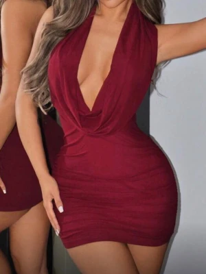 Vinröd kort klänning med öppen rygg - Supersnygg vinröd kort klänning med djup v-ringning och öppen rygg. Klänningen har en tight passform och är ärmlös, vilket ger en riktigt trendig look. Perfekt för dig som vill sticka ut och känna dig extra snygg.