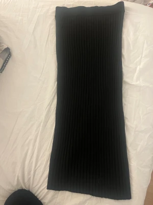Svart ribbad långkjol från Lindex - Svart långkjol från Lindex i ribbad stickad design. Kjolen har en rak och kroppsnära passform som ger en stilren och modern look. Perfekt att matcha med en enkel topp eller stickad tröja. Typ helt ny använt få gånger 