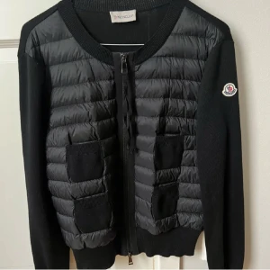 Moncler jacka  - Säljer min snygga moncler jacka i svart! Jättefint skick och inga defekter. Passar till allt! Såklart 100% äkta och köpt av en annan tjej här på Plick och hon köpte den på Vestiaire collective. När hon köpte den va den helt ny! Tveka inte vid frågor och priset kan såklart diskuteras!