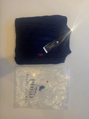 Mörkblå stickad tröja Polo Ralph Lauren -  mörkblå stickad quarter zip tröja från Polo Ralph Lauren, Cirka 1 vecka gammalt i topp skick, tjock och varm inför vintern!