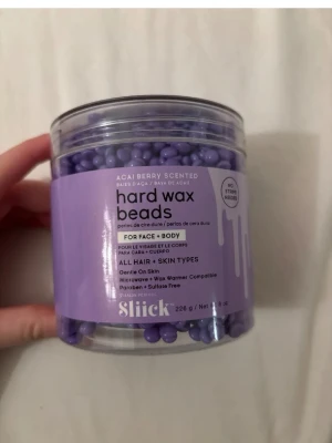 Sliick hårdvaxpärlor acai berry - Lila hårdvaxpärlor med acai berry-doft från Sliick, 226 g. Passar både ansikte och kropp, kompatibel med mikrovågsugn och vaxvärmare. Skonsam mot huden, fri från parabener och sulfater. Perfekt för alla hår- och hudtyper.