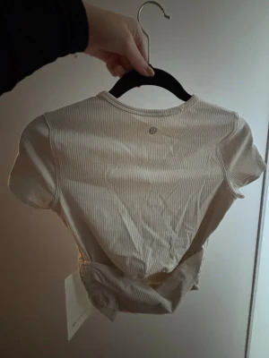 Lululemon topp - ny oanvänd med lappen kvar på - Ny aldrig använd med lappen kvar på Lululemon träningstopp. All it takes back twist ribbed short-sleeve shirt. Nypris 550kr. Storlek 4, som XS