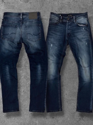 Jeans från Jack & Jones - Snygga blå jeans från Jack & Jones med snygga detaljer. Modellen har smal passform, och bältes hällor. Jeansen är gjorda i denim och har en modern look med diskreta slitningar på benen.