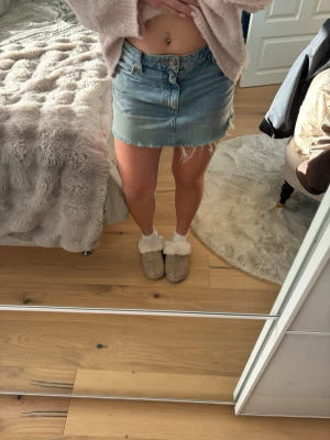 Blå jeanskjol  - Trendig blå jeanskjol med rå, fransig kant och klassiska fem fickor från Zara. Kjolen har en kort passform och stängs med knapp och dragkedja framtill. Passar jätte bra till sommaren💕