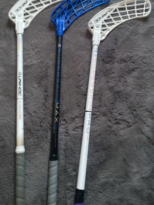 Innebandyklubbor Unihoc - Tre innebandyklubbor, två vita och en svart med blått blad. Alla klubbor är 92cm. Skriv ifall du är intresserad, inga fasta priser är satta.