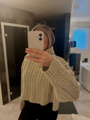 Beige kabelstickad croppad tröja - Säljer en beige kabelstickad tröja med croppad passform. Stickad, mysig och varm tröja som passar perfekt till kallare dagar. Sticks inte!
