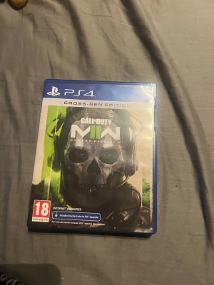 PS4 Cross-Gen Edition spel - Säljer ett PS4-spel i Cross-Gen Edition med blå plastfodral. Spelet har PEGI 18-märkning och kräver internetanslutning. Fodralet är klassiskt blått och spelet är anpassat för både PS4 och PS5. Perfekt för dig som gillar action och gaming. Fodralet har en skada men skivan är intakt.
