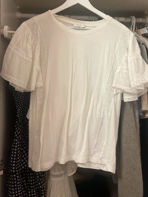 Vit t-shirt med volanger från Sandro!  - Fin vit T-shirt med volanger från Sandro!! 🤍🤍står ingen storlek men skulle säga stl 36