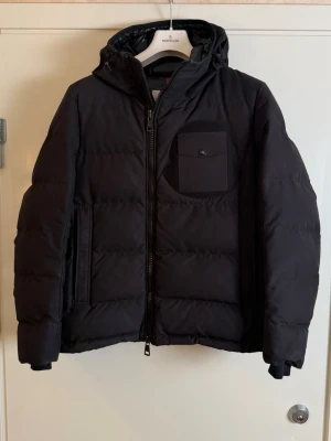 Moncler  - Varumärke: Moncler Modell: Ambert Storlek: 2 Rekommenderad passform: S–M Skick: Bra, serielappen/cartoon är lös. 8/10.  Detaljer: Dunfyllt material. Bröstficka samt framfickor med dragkedjor.  Har du några frågor om produkten är du välkommen att skicka ett meddelande till oss.
