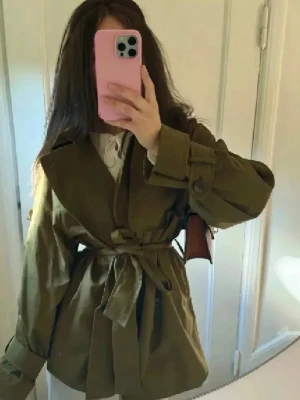 Olivgrön trenchcoat med knytskärp - Säljer min fina gröna oversized short trench coat från COS, fint skick💚i storlek 32 men då den är oversize i modellen tror jag även den funkar 34&36