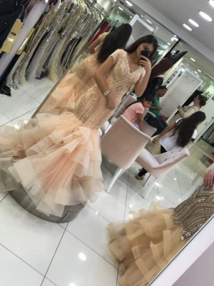 Champagnefärgad långklänning med volang - Säljer en champagnefärgad långklänning med glittriga detaljer och v-ringning. Klänningen har korta ärmar, figurnära passform upptill och volangig kjol i flera lager tyll. Perfekt för bal eller speciella tillfällen. Vissa stenar fallit av men inget fel med klänningen, köpt från Nova sposa i Istanbul känd varumärke. Förlovningsklänning