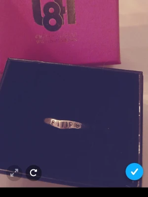 Silverring med texten FILIP - Unik silverfärgad ring med ingraverad text 'FILIP' och ett litet hjärta bredvid. Ringen har en enkel, stilren design och är tillverkad i metall. Perfekt för dig som vill bära ett personligt smycke.