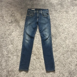 Replay Anbass blå jeans herr - Snygga blå Replay Anbass jeans med klassisk femficksdesign och ljusa slitningar. ”Bra passform W28 L30✔️