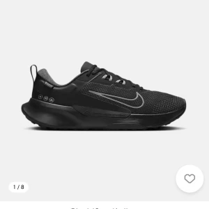 Svarta Nike sneakers med reflexdetaljer - Snygga svarta sneakers från Nike med diskreta reflexdetaljer och en modern siluett. Ovandelen är i mesh och syntet för bra andningsförmåga och komfort. Skon har en låg profil och en robust sula som ger bra grepp. Perfekt för en sportig och stilren look.