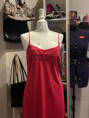 Rosa klänning med tunna axelband  - Elegant rosa klänning från Fransa med tunna axelband och en feminin passform. Den klara rosa färgen gör klänningen perfekt för fest, middag eller sommarkvällar. Klänningen faller fint och ger en stilren och smickrande siluett. Enkel att styla både uppklätt med klackar eller mer avslappnat med sandaler.