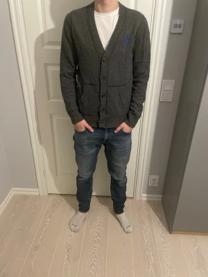 Abercrombie & Fitch cardigan/kofta - Tja säljer en tvär fet mörkgrå kofta från Abercrombie & Fitch med knäppning framtill och två fickor. Klassisk v-ringad design och diskret blå logga på bröstet. Perfekt att slänga över en t-shirt för en avslappnad men stilren look perfekt till dagens mode och perfekt till dig som vill ha en as feta kofta!!! Storlek M killen på bilden är 183cm lång och passar bra🤩 skick 10/10 som ny🙌🏼några frågor eller funderingar är de bara att höra av sig🤗mvh PREMIUM FASHION😁