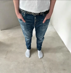 Blåa G star raw straight fit jeans med knappar - Säljer ett par blåa loose fit jeans med slitningar och tydliga tvättade detaljer. Jeansen har knäppning framtill med flera knappar och stora bakfickor med dekorativa sömmar. Perfekta för en avslappnad streetwear-look.