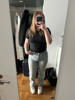 Ljusblå raka jeans - Säljer ett par ljusblå jeans med rak passform  Jeansen har hög midja och stängs med knappar. Materialet är denim i bomull och färgen är tvättad ljusblå. Perfekta till en avslappnad stil.