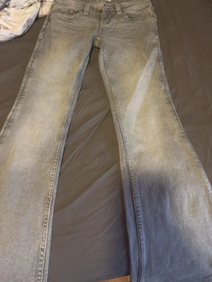 Grå bootcut jeans från Perfect Jeans - Snygga grå bootcut jeans från Perfect Jeans med klassisk femficksdesign och dragkedjegylf. Jeansen har en tvättad look och är tillverkade i bomull med lite stretch för extra komfort.