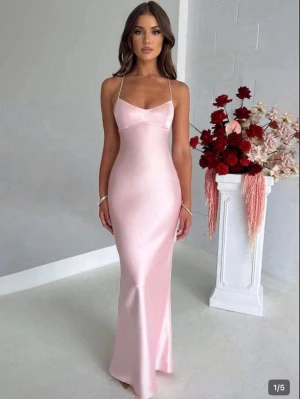Ljusrosa långklänning i satin bal - Ljus rosa bal klänning. Jag är ca 168 lång och den går hela vägen ner till marken på mig💓. Väldigt fin passform och materialet lika så. Ljus elegant ljusrosa långklänning i satin med smala axelband och öppen rygg med snörningsdetalj. Klänningen har figurnära passform och en mjukt skimrande yta som ger en lyxig känsla. Perfekt för balen💗