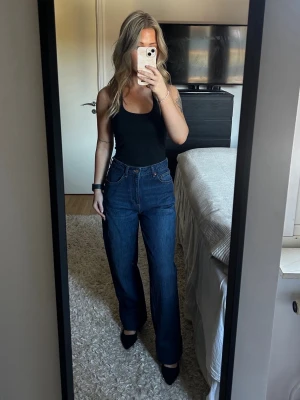 Mörkblå raka jeans med högmidja - Mörkblåa raka jeans med högmidja från NA-KD. Storlek 36. Pris: 300kr. (Ord.pris 599kr.) Använda fåtal gånger, mycket bra skick. OBS! Jag har sytt upp jeansen så de passar mig som är 1.60 dock har jag inte klippt av delen som jag sytt upp så går även att sprätta upp för att få samma längd som innan. Skriv meddelande om det önskas fler bilder eller om det är några funderingar. 💛