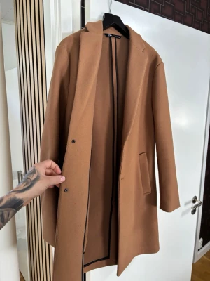 Kamelbrun kappa från Zara Man - HerrKappa från Zara i storlek M, använd endast en gång. Billigare vid snabb affär. 
